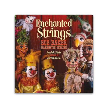 Book cover of 'Enchanted Strings' featuring marionette puppets with a red curtain background.